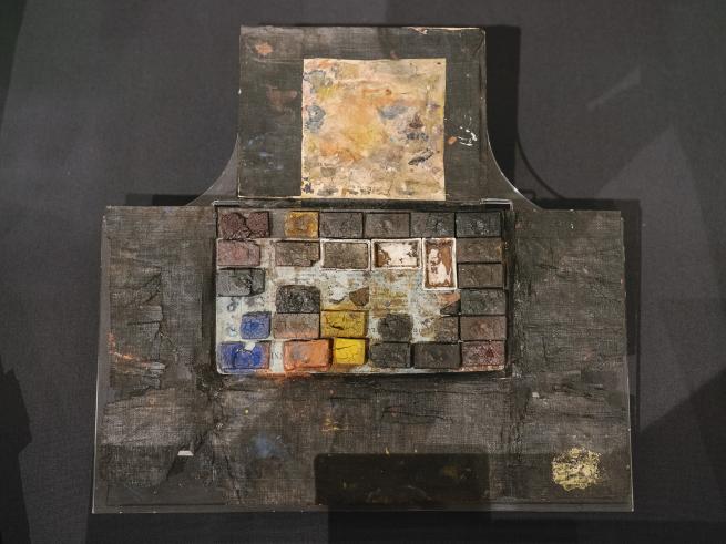 a very old paint pallette in a black case dating back to turner period with dulled colours and edging 
