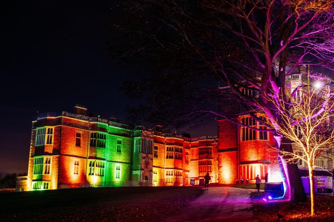 Temple Newsam House illuminated by coloured lights in the evening.