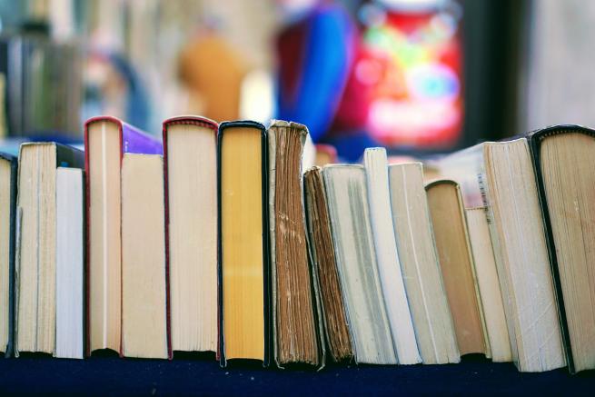 View of the top of a pile of books, stacked on their sides