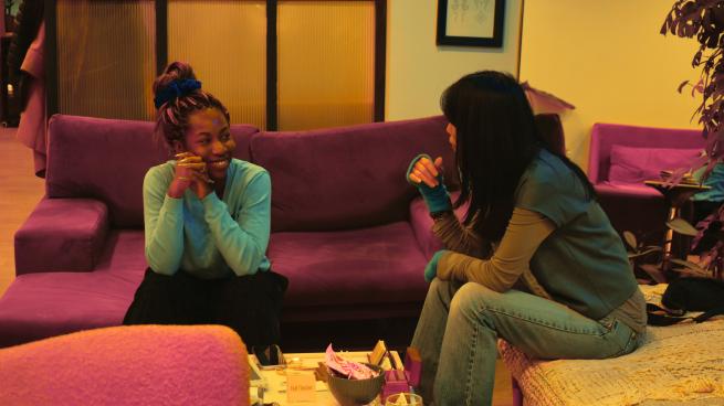 Two women on comfy sofas enjoy a discussion