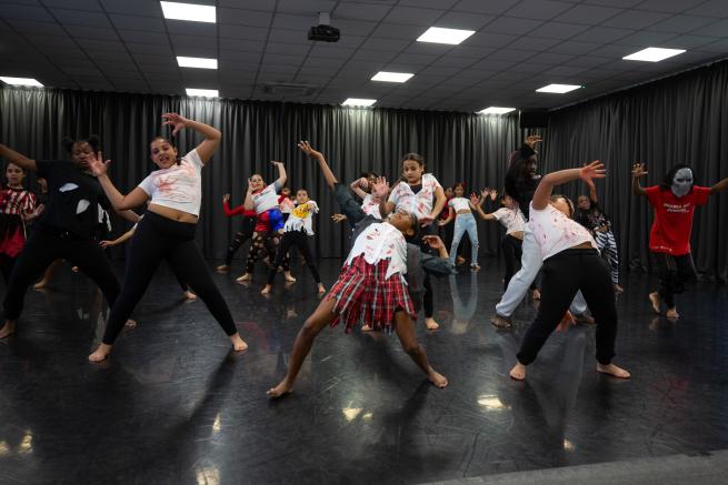 a group of young dancers dancing in a large dance studio