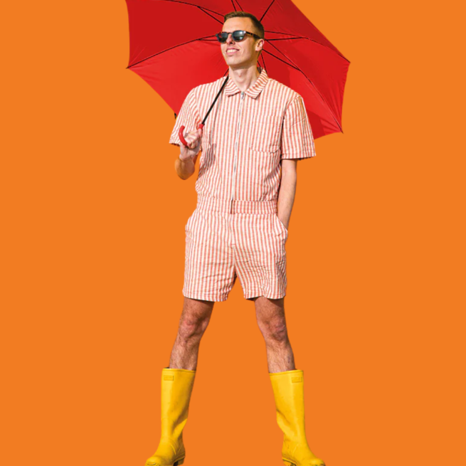 Harry Baker in yellow wellies holding a red umbrella