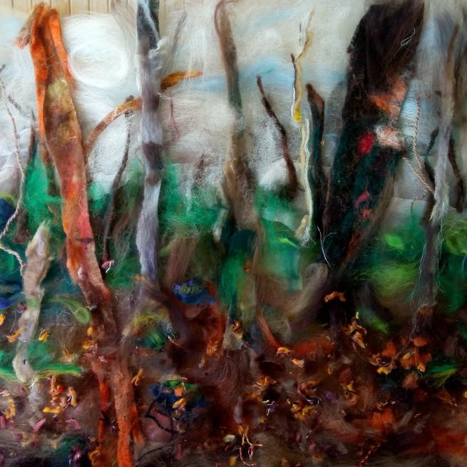 Brown felted trees against a green and white backdround