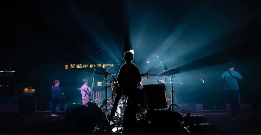 a drummer on a stage photographed from behind