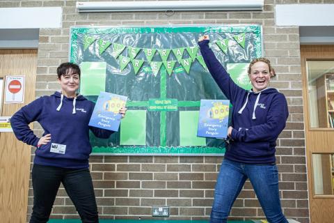 two women standing in front of a display board