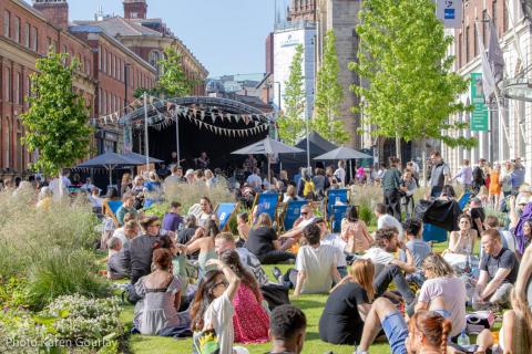 People sitting in the sunshine enjoying the 2022 Jazz Festival at the Welcome to Leeds Festival Tent