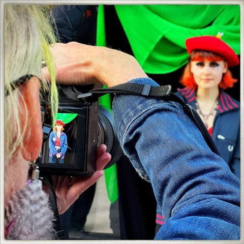 photographer being photographed photographing a model in a red beret