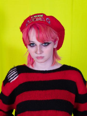 a young woman in a red beret and striped jumper