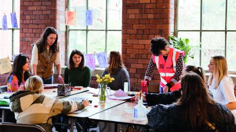 young people at a table with windows behind them