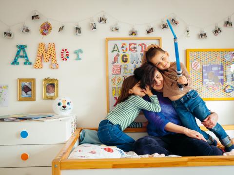 a family group hugging on a bed