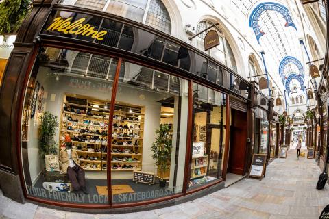 The shop front of Welcome Skate Store featuring an assortment of clothing and footwear in the shop windows.
