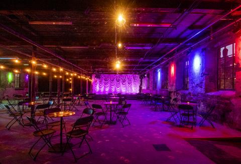 A large industrial space ,with untouched features ,with moody lighting & mirror balls.