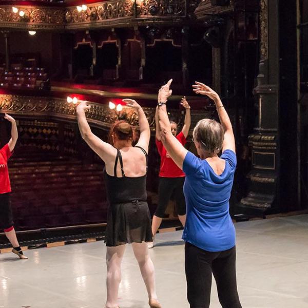 People learning dance moves on stage