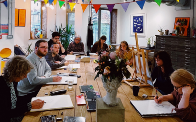 A photo from a Saltaire Art School drawing class with students around a table with sketch books