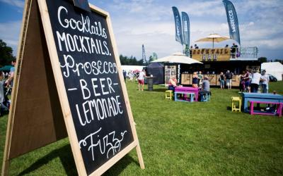 Chalkboard sign advertising a festival, featuring various beerand event details.