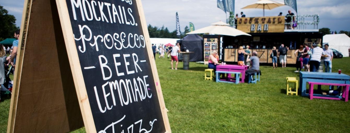 Chalkboard sign advertising a festival, featuring various beerand event details.