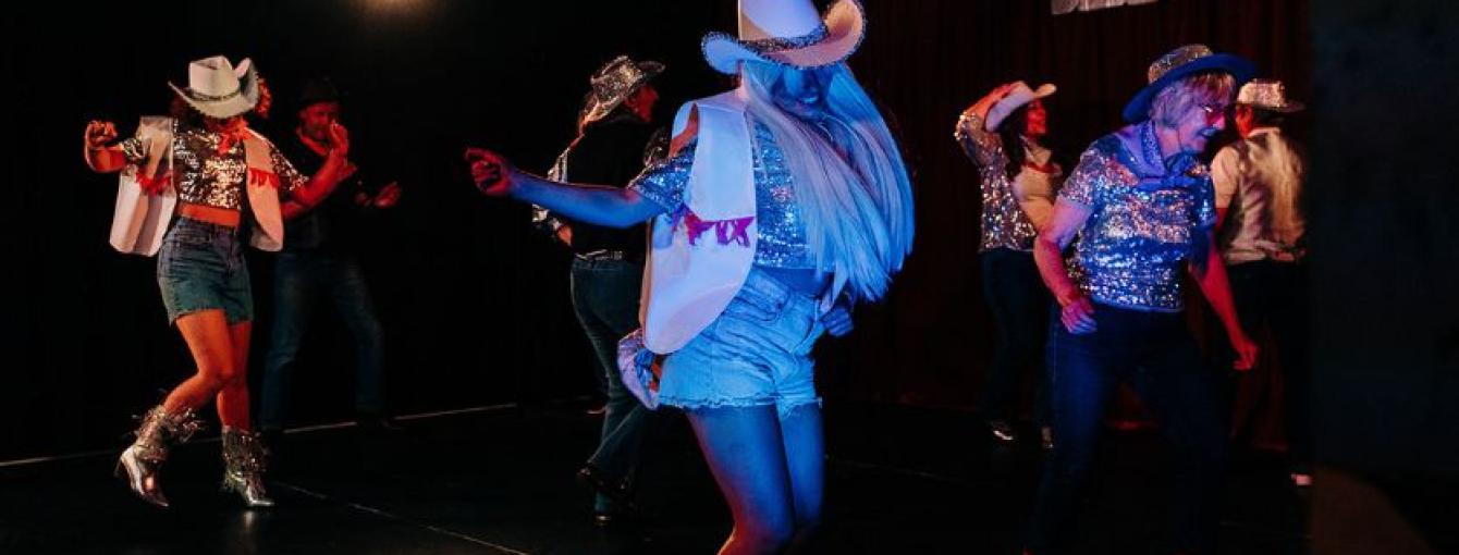 People dancing in cowboy hats and boots